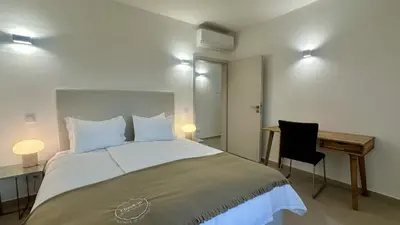 a bedroom with a large bed with a desk and a chair at Amêndoa by Check-in Portugal in Quarteira