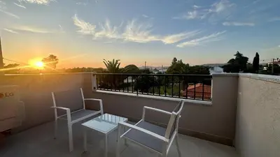 two chairs and a table on a balcony with the sunset at Amêndoa by Check-in Portugal in Quarteira