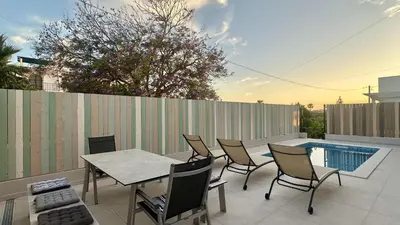 a patio with a table and chairs and a pool at Amêndoa by Check-in Portugal in Quarteira