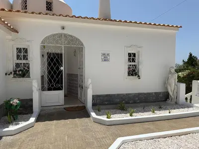 a white house with a gate and a courtyard at Solar dos Lirios in Loulé