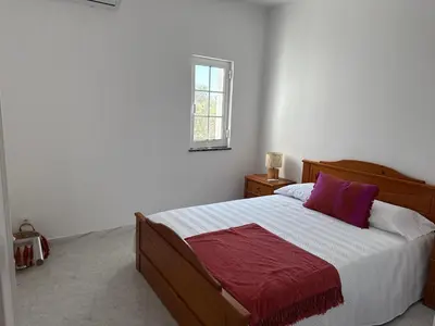 a bedroom with a bed with a red and white blanket at Solar dos Lirios in Loulé