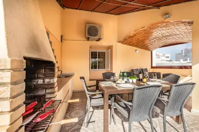a dining room with a table and a fireplace at Villa Mogan in Albufeira