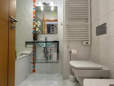a bathroom with a toilet and a sink and a mirror at Monte da Vinha By FHR in Quarteira