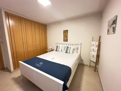 a bedroom with a white bed with a blue blanket at Monte da Vinha By FHR in Quarteira