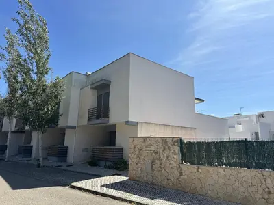 a white house with a stone fence in front of it at Monte da Vinha By FHR in Quarteira