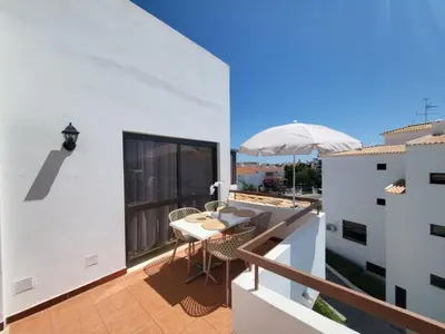 a patio with a table and chairs on a balcony at Sun House in Albufeira