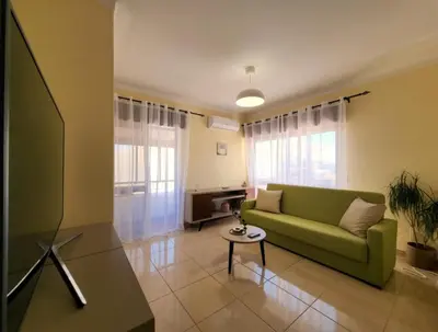 a living room with a green couch and a table at Sun House in Albufeira