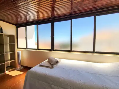 a bedroom with a bed and large windows at Sun House in Albufeira