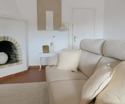 a living room with a couch and a fireplace at Manso da Falésia in Olhos de Água