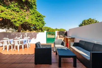 a patio with chairs and tables and a fence at Manso da Falésia in Olhos de Água