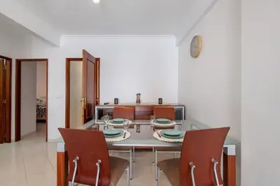 a dining room with a glass table and chairs at Excellent Apartment in Olhos D´Água in Olhos de Água