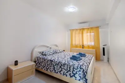 a bedroom with a bed with blue towels on it at Excellent Apartment in Olhos D´Água in Olhos de Água