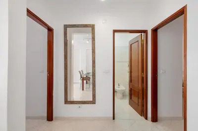 two mirrors on a wall next to a bathroom at Excellent Apartment in Olhos D´Água in Olhos de Água
