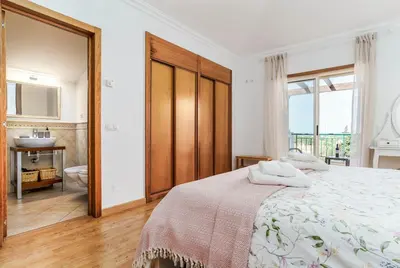 a bedroom with a bed and a bathroom with a sink at Bright 3-BR in Guia with Shared Pool by Lisbeyond in Guia