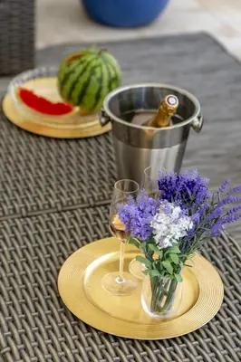 a table with a vase of flowers and a bucket of wine at Villa Velluto in Albufeira