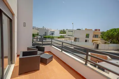 a balcony with two chairs and a couch on a building at Villa Velluto in Albufeira
