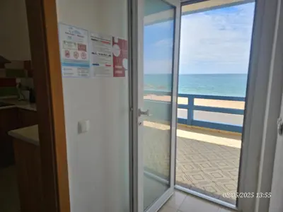 a sliding glass door with a view of the ocean at Blife Vistaya private rooms at Faro beach in Faro