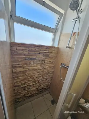 a bathroom with a stone wall and a window at Blife Vistaya private rooms at Faro beach in Faro