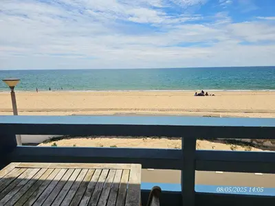 a view of a beach with a blue bench at Blife Vistaya private rooms at Faro beach in Faro