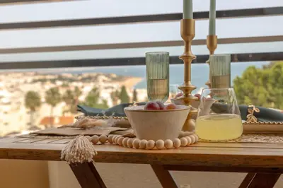 a table with a bowl of fruit and a glass of wine at Ocean glimpse in Albufeira
