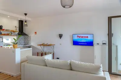 a living room with a white couch and a tv on the wall at Ocean glimpse in Albufeira