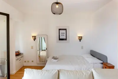 a white bedroom with two beds and a mirror at Ocean glimpse in Albufeira