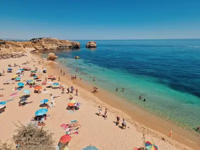 a group of people on a beach with umbrellas at Villa São Rafael in Albufeira