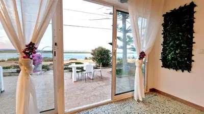 a room with a sliding glass door with a view of the ocean at Lazaro Beach House in Faro