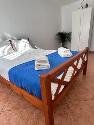 a bedroom with a bed with towels on it at Lazaro Beach House in Faro