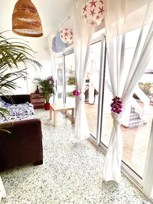 a living room with white curtains and flowers at Lazaro Beach House in Faro