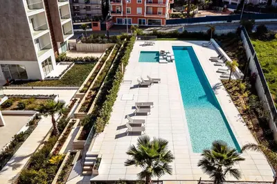 a swimming pool with lounge chairs and buildings at Modern 1-Bed Apartment with Terrace Albufeira in Albufeira