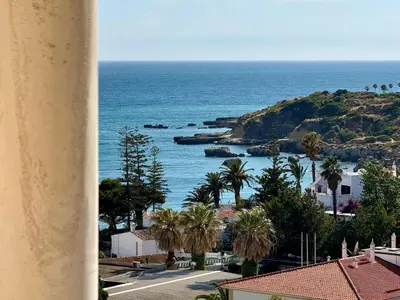 a view of a beach with palm trees and the ocean at Blue Wave Albufeira in Albufeira