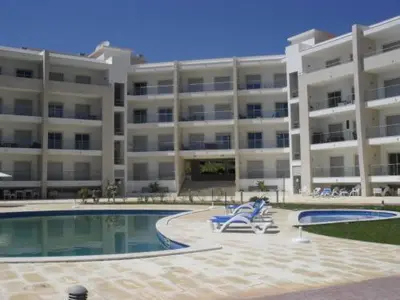 a large apartment building with a swimming pool and chairs at Monte da Eira apt 62 in Albufeira