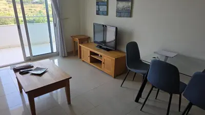 a living room with a tv and a table and chairs at Monte da Eira apt 62 in Albufeira