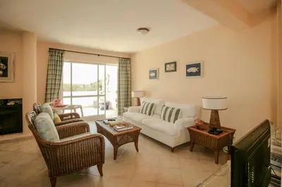 a living room with a white couch and chairs at FLH Quinta do Lago Retreat with Terrace & Pool in Almancil