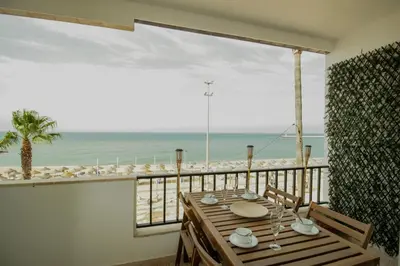 a room with a table and a view of the beach at FLH Quarteira Seaview in Quarteira