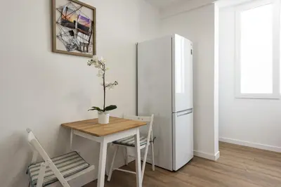 a small kitchen with a table and a refrigerator at Garret - Faro Apartment by HD in Faro