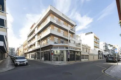 a tall building on a street with cars parked in front at Garret - Faro Apartment by HD in Faro