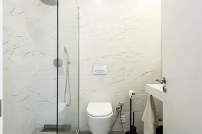 a bathroom with a toilet and a glass shower at Garret - Faro Apartment by HD in Faro
