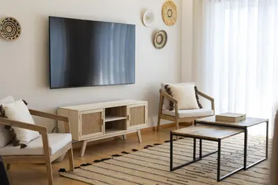 a living room with two chairs and a flat screen tv at Villa da Ria - by HD Properties in Monte Negro