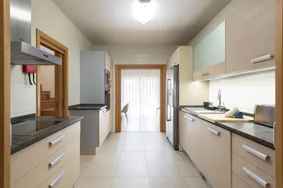 a kitchen with wooden cabinets and black counter tops at Villa da Ria - by HD Properties in Monte Negro