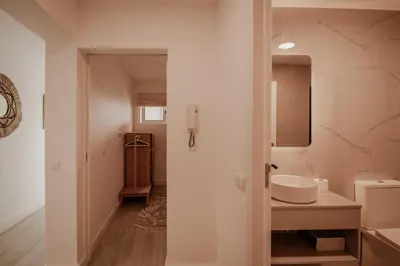 a white bathroom with a sink and a mirror at FLH Albufeira Boho Chic with Balcony in Albufeira