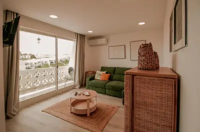 a living room with a green couch and a large window at FLH Albufeira Boho Chic with Balcony in Albufeira