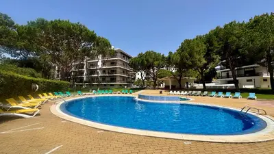 a swimming pool with chairs and a building in the background at Sun by Check-in Portugal in Albufeira