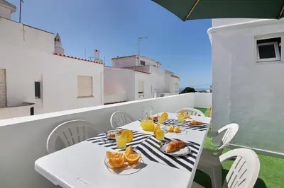 a white table with food and oranges on a balcony at Casa Flôr in Albufeira