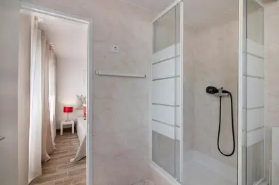a shower with a glass door in a bathroom at Casa Flôr in Albufeira