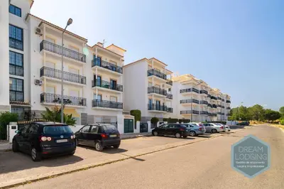 a group of cars parked in a parking lot next to buildings at O Mar - Dream Lodging in Olhos de Água