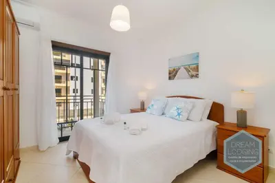 a bedroom with a white bed with a window at O Mar - Dream Lodging in Olhos de Água