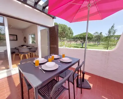a table and chairs with an umbrella on a patio at V2 - Bungalow 12 in Quarteira