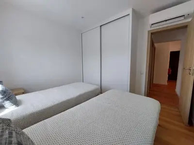 a white bedroom with two beds and a closet at V2 - Bungalow 12 in Quarteira